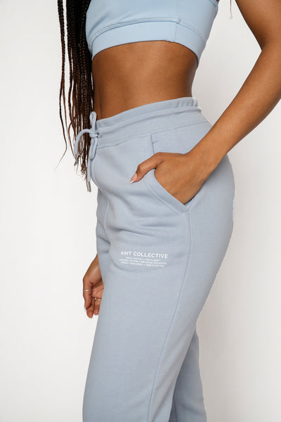 Model wearing KIHT sweat pant Joggers with logo close up in blue and white