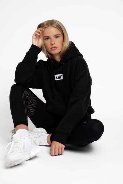 Ethical UK activewear Black slightly oversized drop shoulder unisex hoodie with Kiht logo embroidered patch on the front in contrasting white. Super soft thick fabric with chunky cord detail and hidder inner pockets make this our ultimate hoodie. 