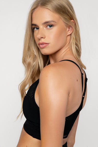  UK ethical active wear crop top in black with adjustable strap with scoop neck punched panel detail on the front and back. Removable bust cups and compressive super soft fabric