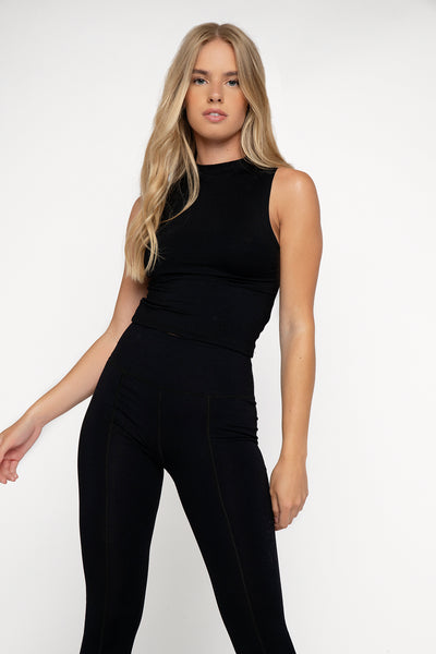 Ethical UK activewear fitted high neck sleeveless top in black with mid crop length hitting the top of high waisted leggings