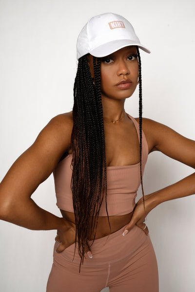 Female wearing KIHT Collective activewear with a cap in white, front shot, for Gym and everyday