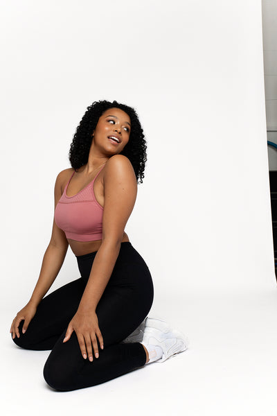  UK ethical active wear crop top in pink with adjustable strap with scoop neck punched panel detail on the front and back. Removable bust cups and compressive super soft fabric